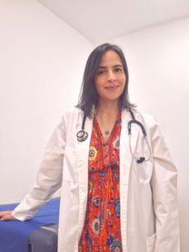 Dra. María Camila Echavarría de pie en su consultorio, con bata blanca y estetoscopio